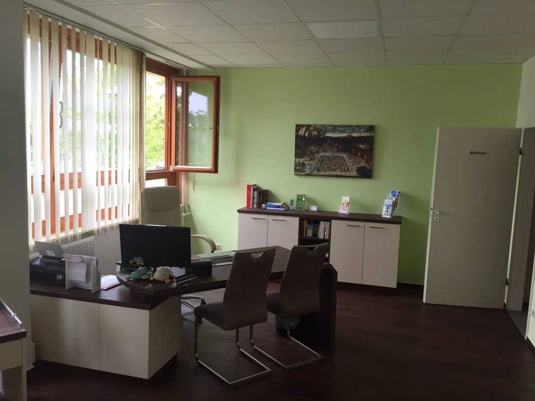 Sprechzimmer mit Schreibtisch und Sideboard
